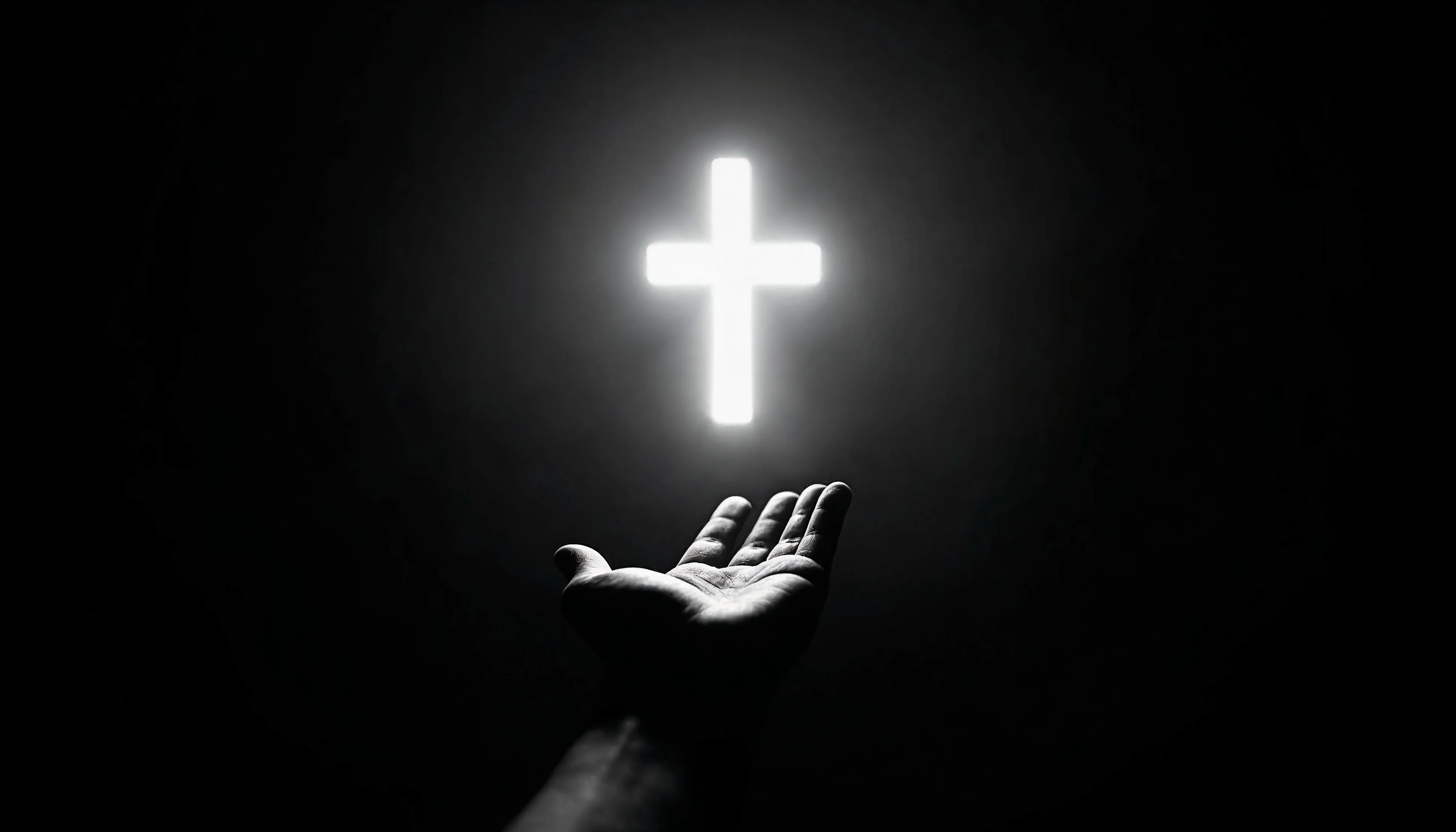 A glowing cross above an open book held in an outstretched hand